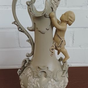 Vintage keramische kan met reliëf van een klimmende cherubijn